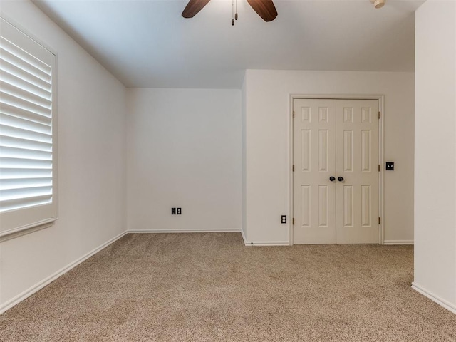 interior space featuring light colored carpet and ceiling fan