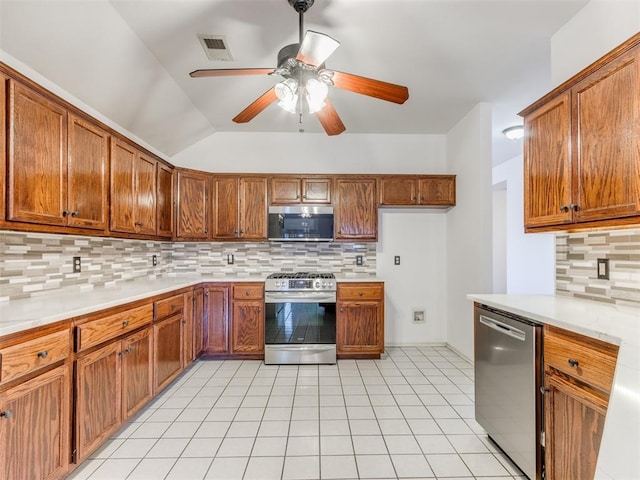 kitchen featuring tasteful backsplash, lofted ceiling, light tile patterned floors, ceiling fan, and stainless steel appliances