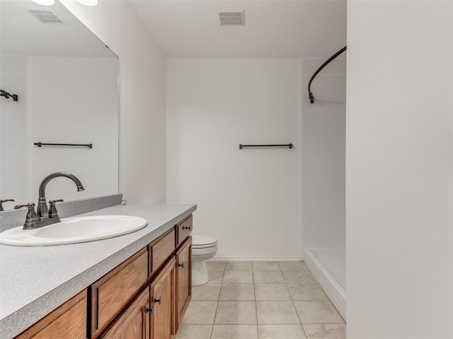 bathroom with tile patterned flooring, vanity, walk in shower, and toilet