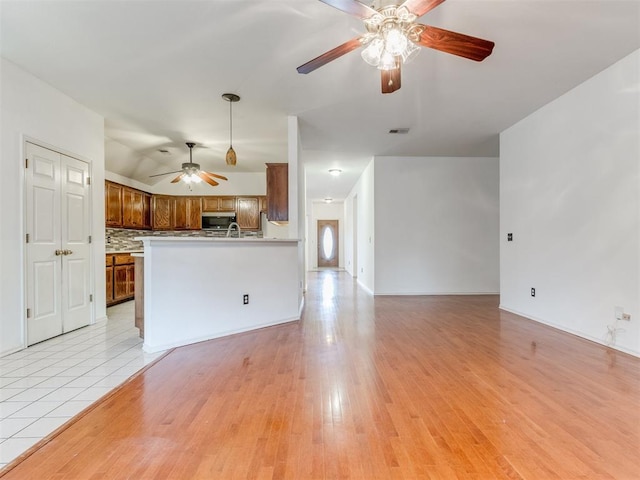 unfurnished living room featuring ceiling fan and light hardwood / wood-style floors