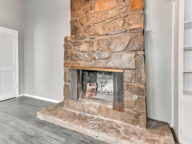 room details with hardwood / wood-style flooring and a stone fireplace