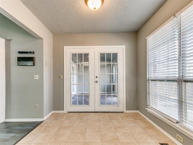 doorway featuring light tile patterned flooring, a textured ceiling, and french doors