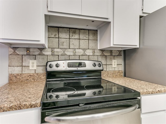 kitchen featuring tasteful backsplash, white cabinetry, and stainless steel range with electric cooktop