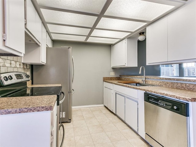 kitchen with light tile patterned flooring, sink, tasteful backsplash, stainless steel appliances, and white cabinets