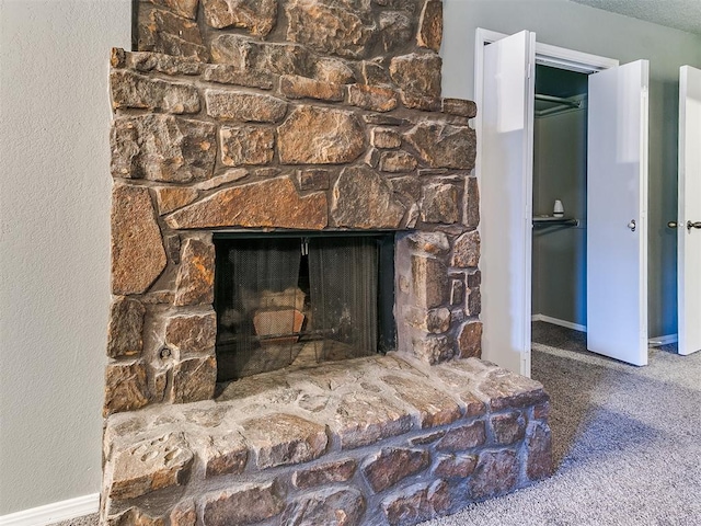 room details with a stone fireplace and carpet floors