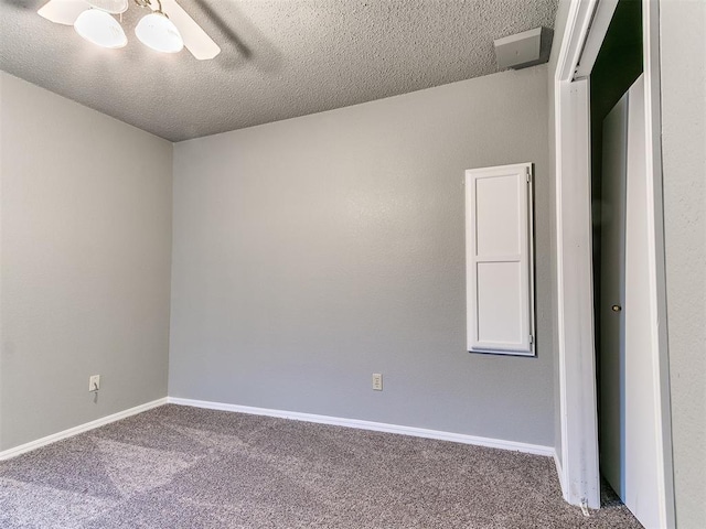 empty room with carpet floors and a textured ceiling