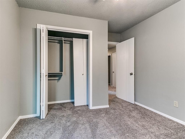 unfurnished bedroom with carpet floors, a closet, and a textured ceiling