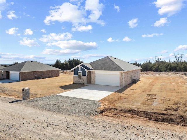 view of front of home with a garage and central air condition unit