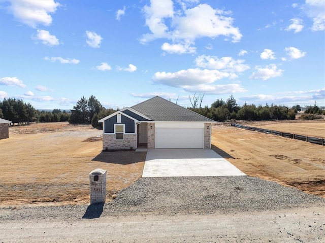 view of front of home featuring a garage and a rural view