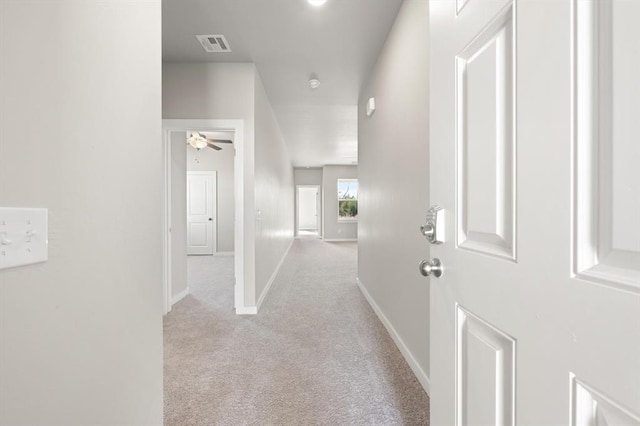 hall with light colored carpet