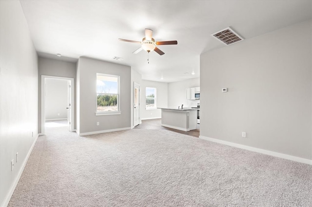 unfurnished living room with light carpet and ceiling fan