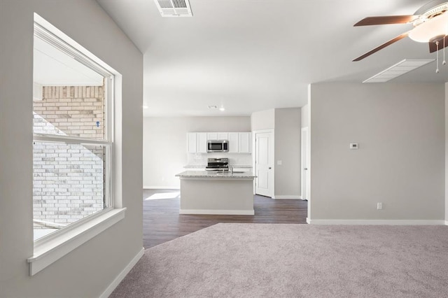 carpeted living room with sink and ceiling fan