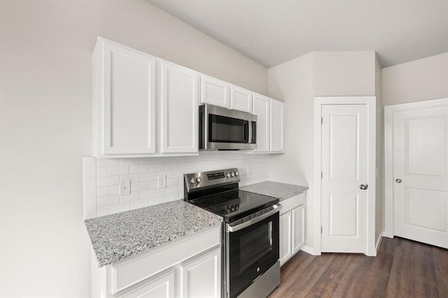 kitchen featuring white cabinetry, decorative backsplash, light stone counters, stainless steel appliances, and dark wood-type flooring