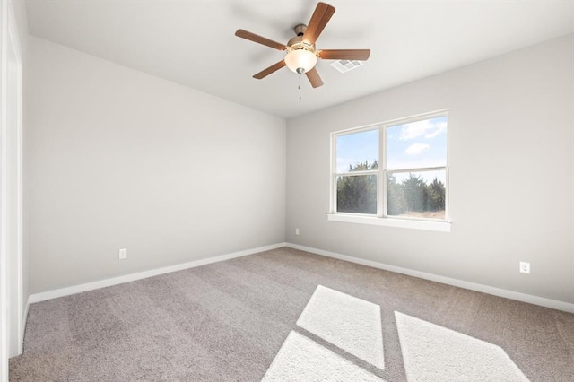 carpeted spare room featuring ceiling fan