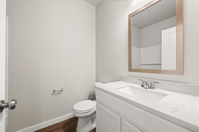 bathroom with hardwood / wood-style flooring, vanity, and toilet