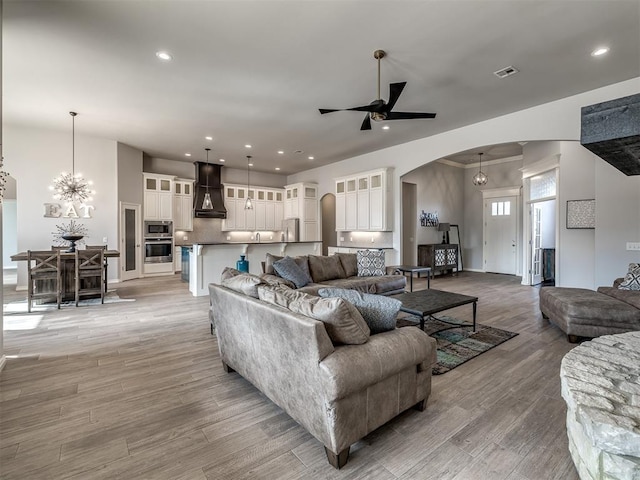 living room with ceiling fan with notable chandelier