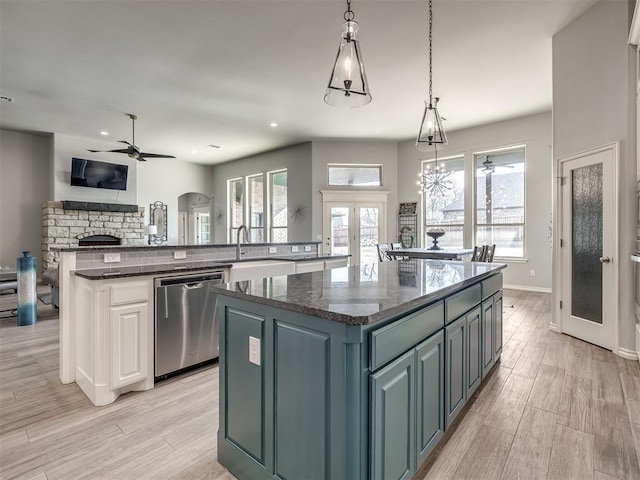 kitchen with french doors, stainless steel dishwasher, a center island, and sink