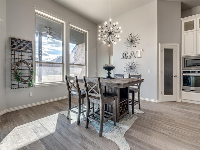 dining space featuring light hardwood / wood-style flooring and a chandelier