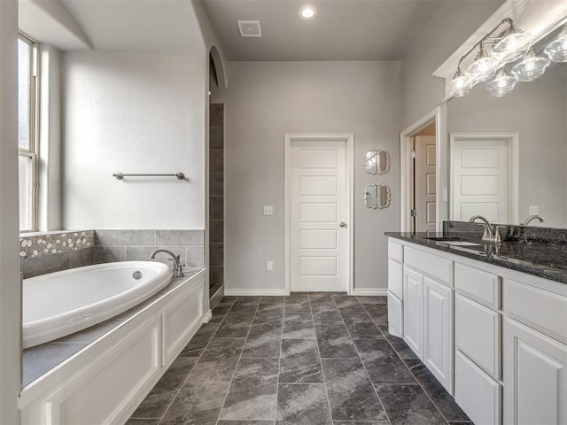 bathroom with a bathing tub and vanity