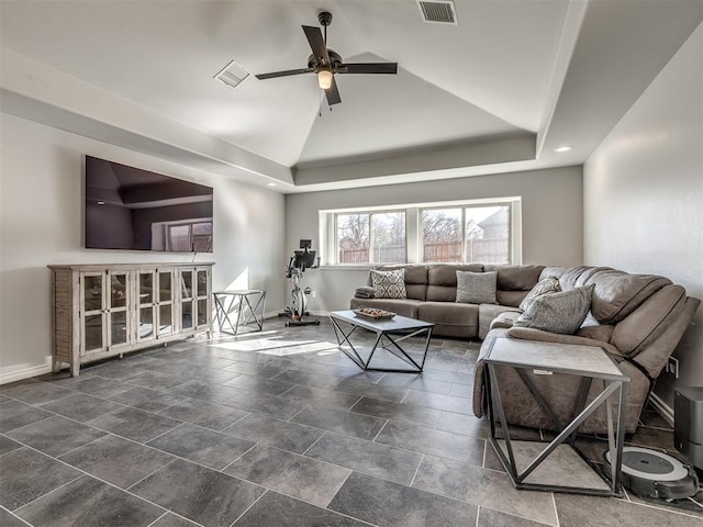 living room with ceiling fan, a tray ceiling, and vaulted ceiling