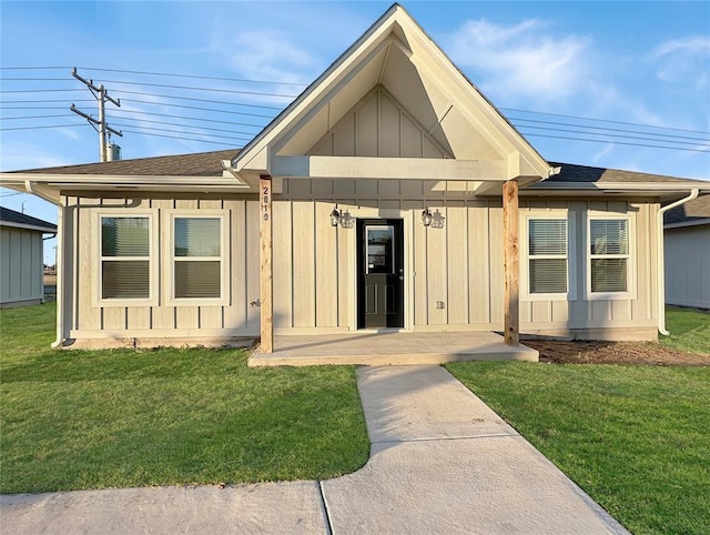 rear view of property featuring a lawn