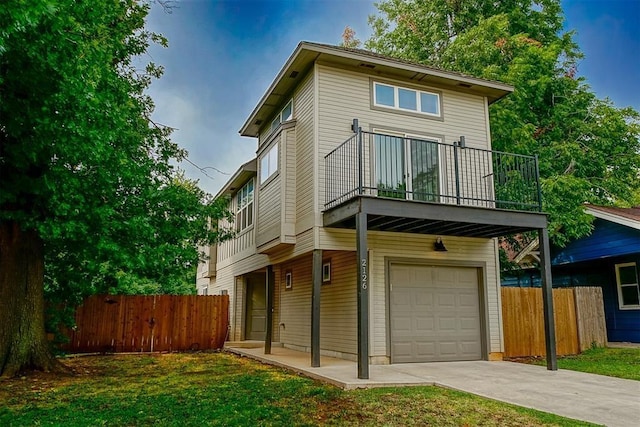 view of front of home with a balcony, a garage, and a front yard