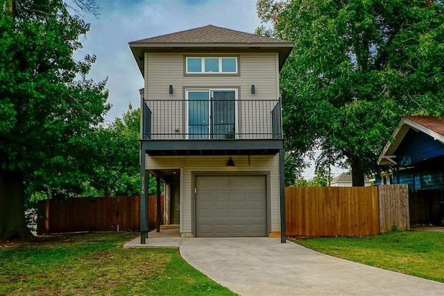 view of front of house featuring a garage, a front yard, and a balcony