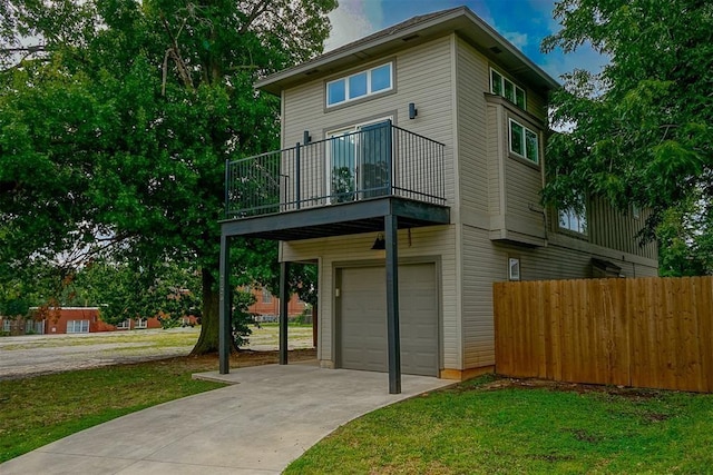 view of front of house featuring a balcony, a garage, and a front yard