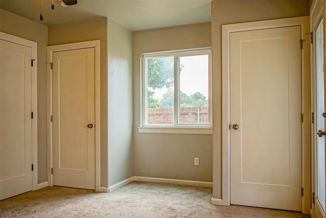 unfurnished bedroom with light colored carpet and ceiling fan