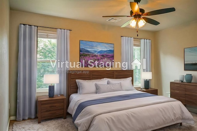 bedroom featuring multiple windows, light carpet, and ceiling fan