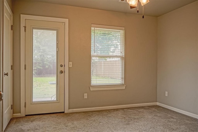 doorway featuring light carpet and ceiling fan