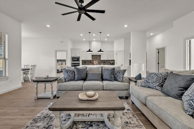 living room featuring ceiling fan and light wood-type flooring