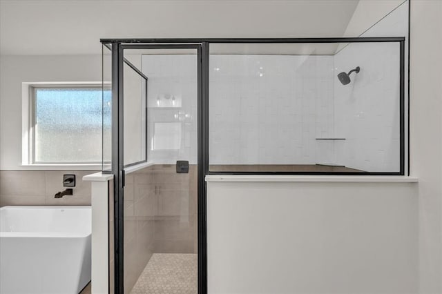 bathroom featuring shower with separate bathtub