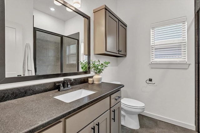 bathroom featuring vanity, a shower with door, and toilet