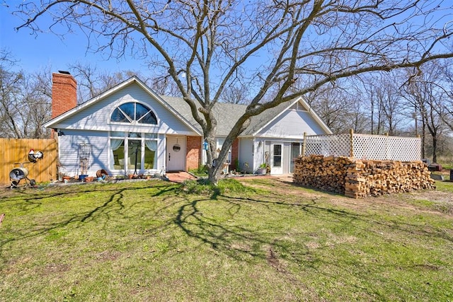 rear view of property featuring a lawn