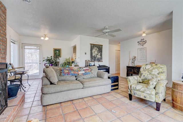 living room featuring light tile patterned flooring, ceiling fan, and a textured ceiling