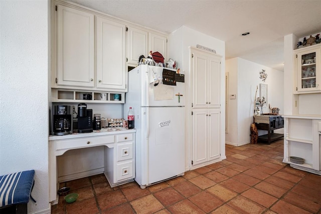 kitchen with white refrigerator and white cabinets