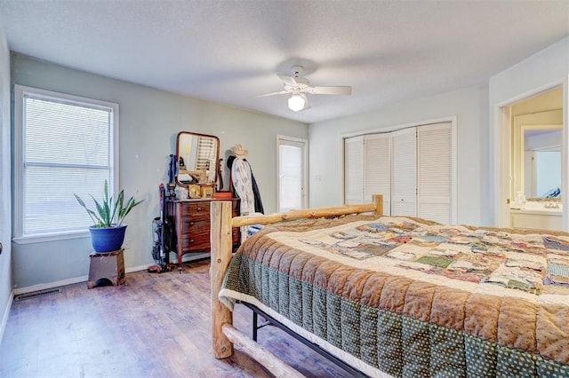 bedroom featuring hardwood / wood-style floors, ensuite bath, a closet, and ceiling fan