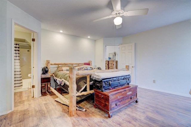 bedroom featuring ceiling fan, ensuite bathroom, and light hardwood / wood-style flooring