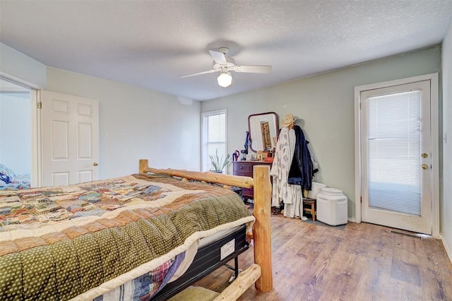 bedroom featuring a textured ceiling, light hardwood / wood-style floors, and ceiling fan