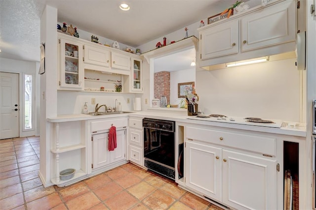 kitchen with white electric cooktop, dishwasher, white cabinetry, sink, and a textured ceiling