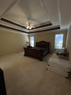 bedroom with multiple windows, a tray ceiling, ceiling fan, and carpet flooring