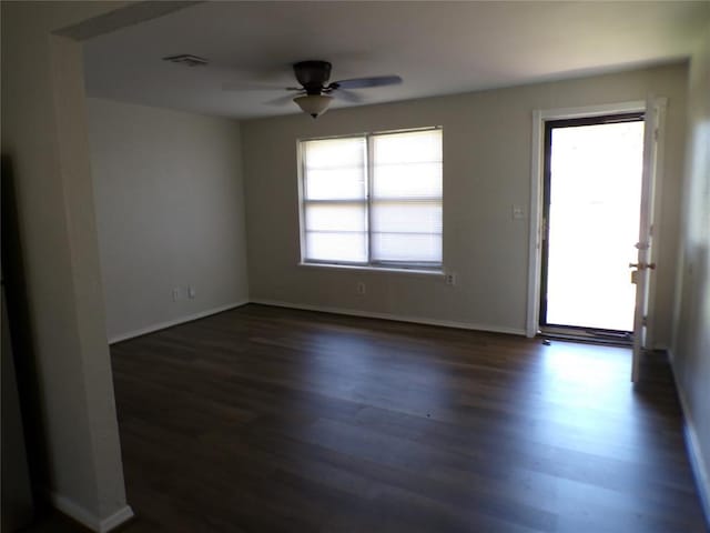 empty room with ceiling fan and dark hardwood / wood-style flooring