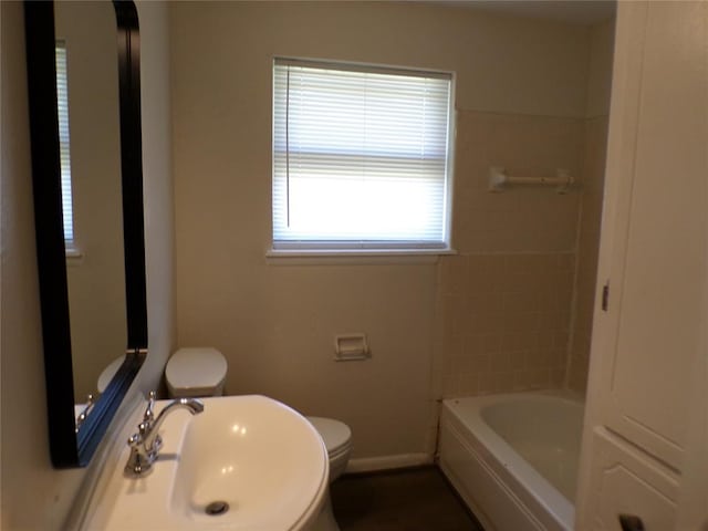 bathroom with a bathing tub, sink, and toilet