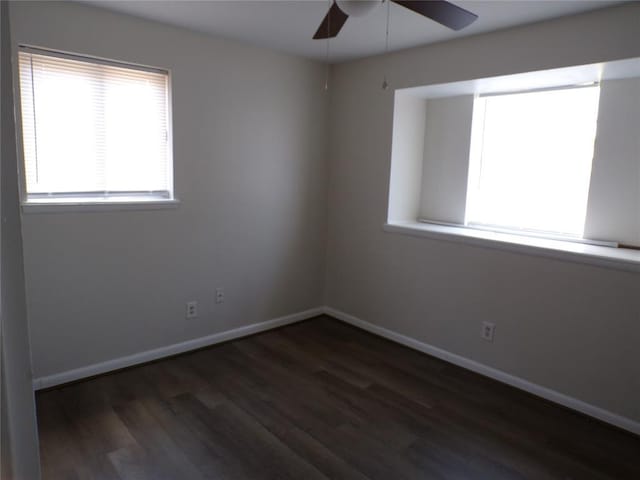 empty room featuring dark wood-type flooring and ceiling fan