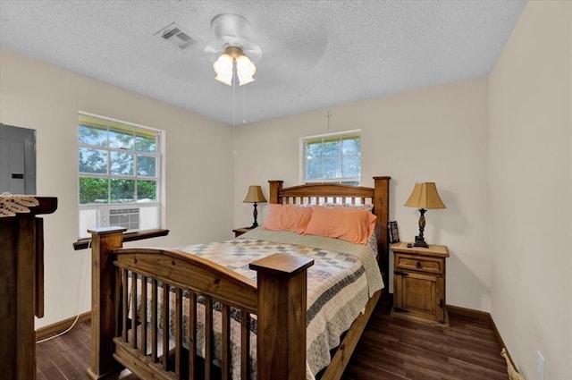 bedroom featuring multiple windows, dark wood-type flooring, electric panel, and ceiling fan