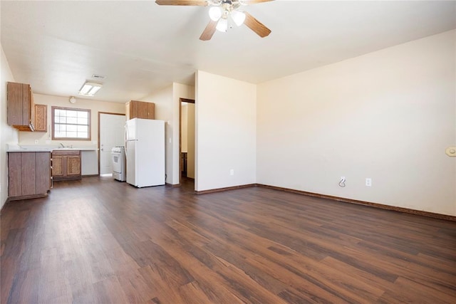 unfurnished living room with dark wood-type flooring, sink, and ceiling fan