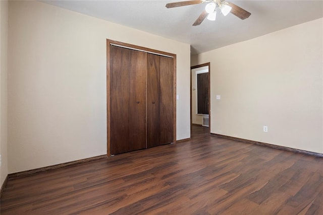 unfurnished bedroom with dark hardwood / wood-style floors, ceiling fan, and a closet