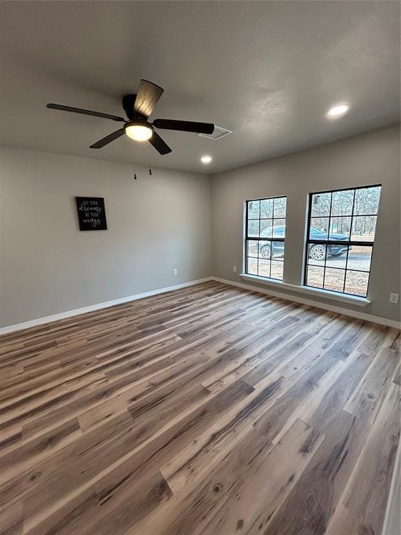 empty room with a ceiling fan, recessed lighting, baseboards, and wood finished floors