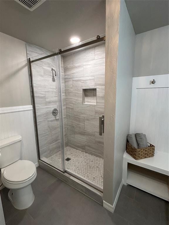 full bath featuring toilet, a shower stall, visible vents, and tile patterned floors